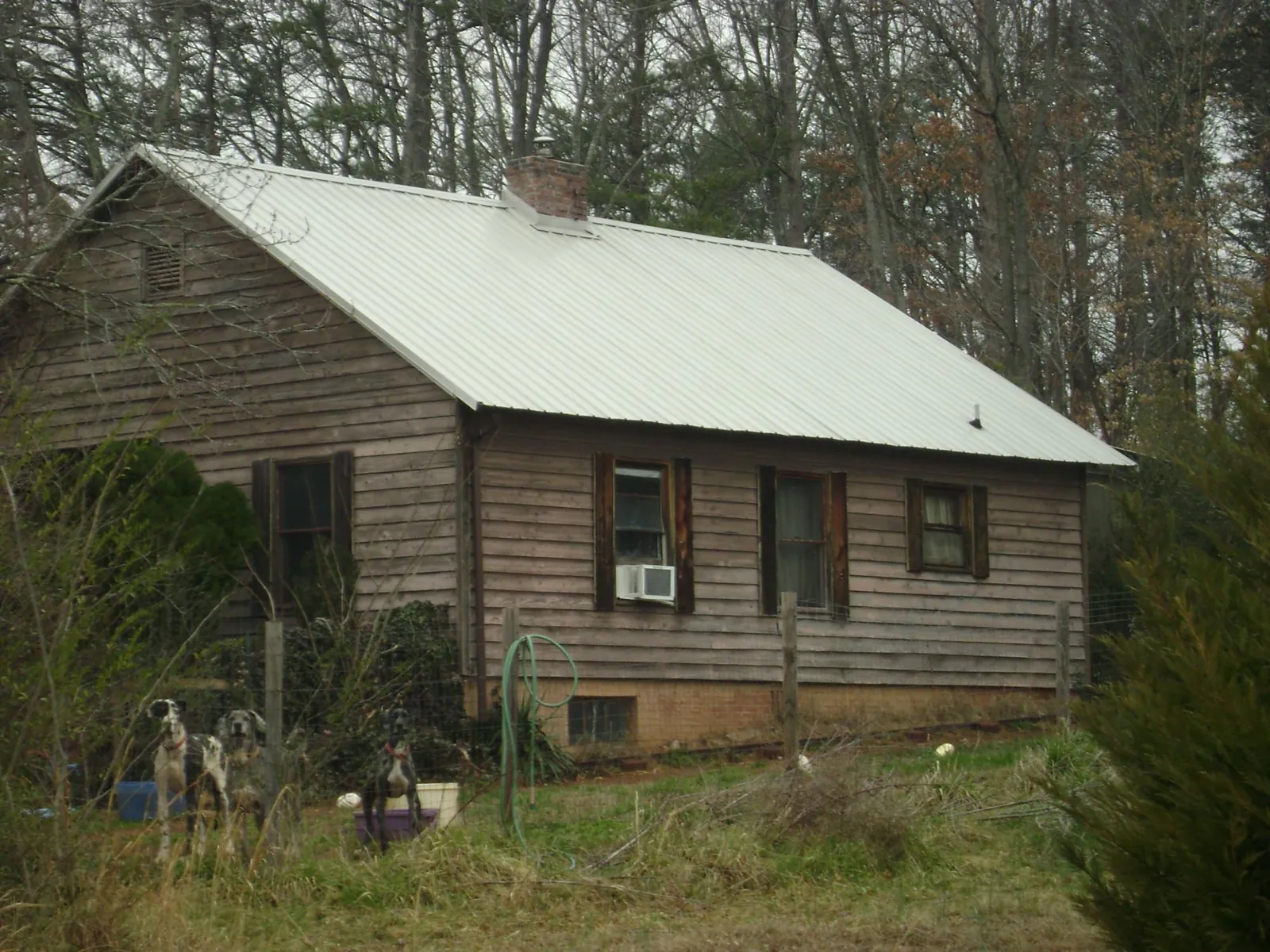 White metal roof on an old wood sided farmhouse, from a Metal Roof Installation job in Minden
